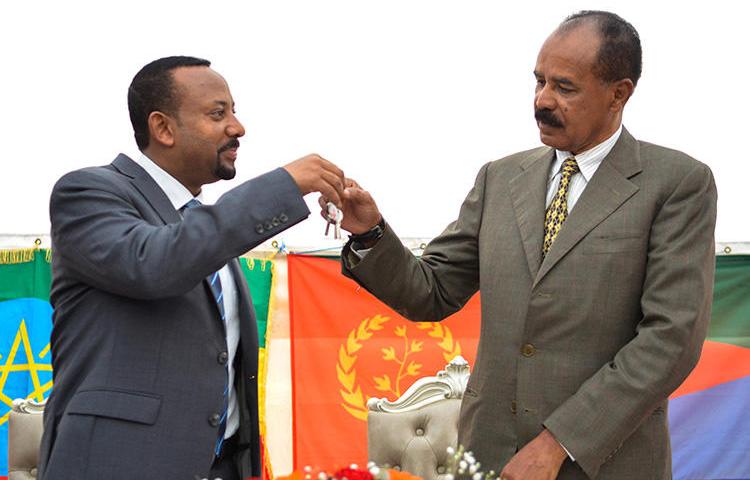 Ethiopian Prime Minister Abiy Ahmed, left, and Eritrean President Isaias Afwerki celebrate the reopening of the Embassy of Eritrea in Addis Ababa on July 16. An Ethiopian news crew was attacked and their driver killed while traveling to the capital to cover the visit. (AFP/Michael Tewelde)