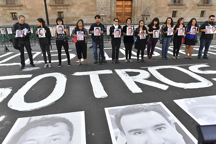 Members of the press hold images of colleagues during a protest against the murder or disappearance of journalists and photojournalists in Mexico, in front of the National Palace in Mexico City on June 1, 2018. Mexican journalist and media owner Rubén Pat was killed in Playa del Carmen, in the southern Mexican state of Quintana Roo, on July 24. (AFP/Yuri Cortez)