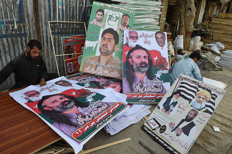 Posters of political parties for Pakistan's July 25 elections are prepared in Quetta. (AFP/Banaras Khan)