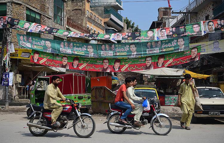Election posters hang next to a street in Rawalpindi, ahead of elections on July 25. Pakistan's journalists say retaliation against critical reporting is making them self-censor to try to avoid retaliation. (AFP/Farooq Naeem)