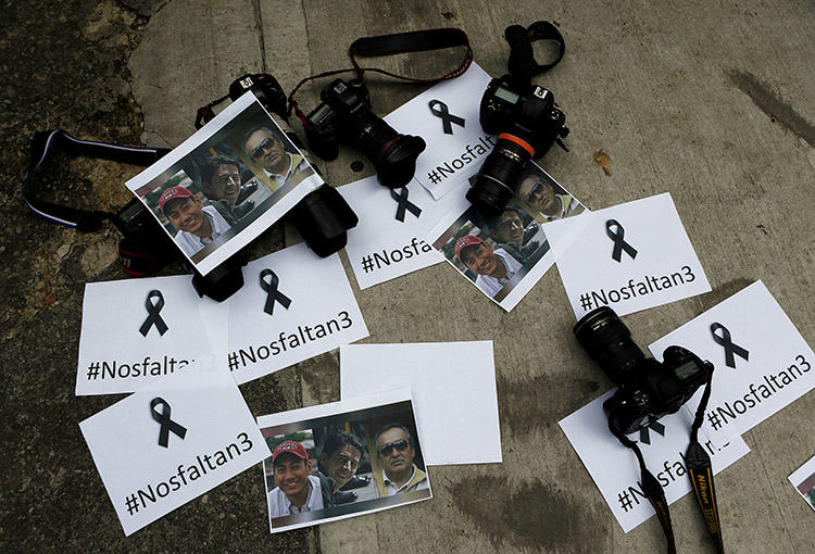 Fotógrafos colombianos dejan cámaras y fotos frente a la embajada ecuatoriana para protestar la muerte del periodista Javier Ortega, del fotógrafo Paúl Rivas y del chofer Efraín Segarra. (Reuters/Jaime Saldarriaga)