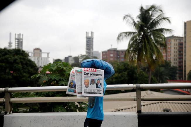 A vendor carrying newspapers walks past on a bridge in Lagos on July 22, 2016. The Nigerian Broadcasting Commission closed the Broadcasting Service of Ekiti State on July 14, 2018. (Reuters/Akintunde Akinleye)