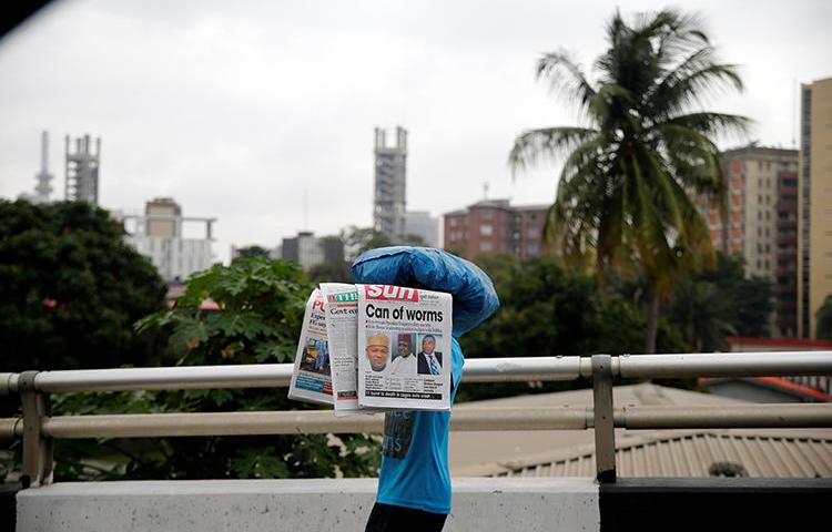 A vendor carrying newspapers walks past on a bridge in Lagos on July 22, 2016. The Nigerian Broadcasting Commission closed the Broadcasting Service of Ekiti State on July 14, 2018. (Reuters/Akintunde Akinleye)