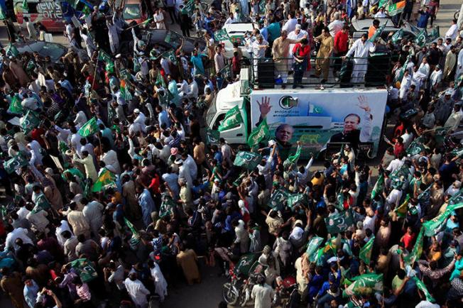 Supporters of the Pakistan Muslim League-Nawaz march toward the airport to welcome former Prime Minister Nawaz Sharif, in Lahore, Pakistan, on July 13, 2018. Pakistani police arrested and beat a Norwegian TV reporter covering a Sharif rally in Gujrat on July 13. (Reuters/Mohsin Raza)