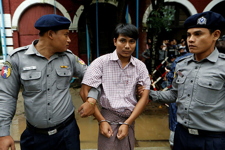 Detained Reuters journalist Kyaw Soe Oo is escorted by police while leaving Insein court in Yangon, Myanmar on July 9, 2018. (Reuters/Ann Wang)