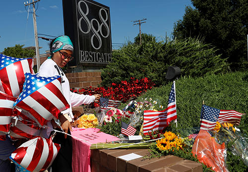 A resident lays an American flag at a memorial outside the Capital Gazette offices. (Reuters/Leah Millis)