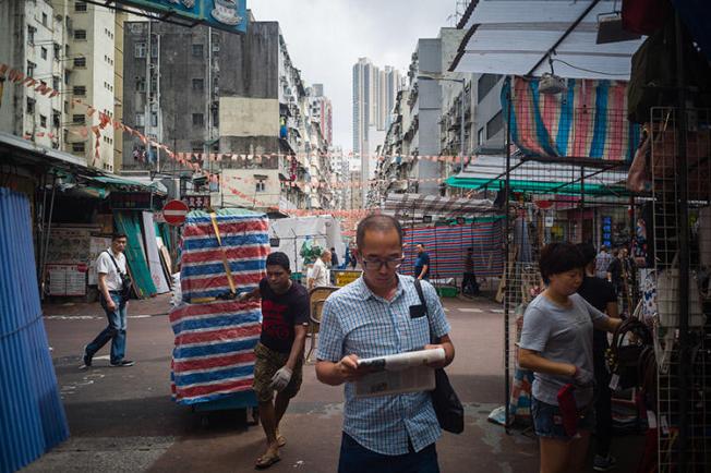 A man reads a newspaper while walking through a market in Hong Kong in May 2018. The Hong Kong Journalists Association says press freedom in the administrative region is in decline. (AFP/Anthony Wallace)