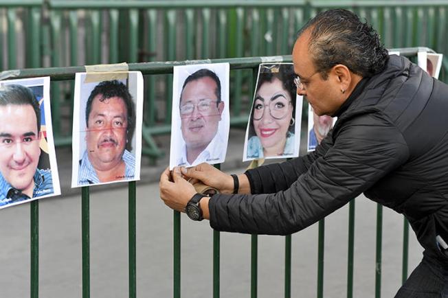 A member of the press hangs pictures of colleagues during a protest against the murder or disappearance of journalists in Mexico in front of the National Palace in Mexico City on June 1, 2018. Mexican cameraman Javier Enrique Rodríguez Valladares was killed in Cancún, in the southern state of Quintana Roo, on August 29. (AFP/Yuri Cortez)