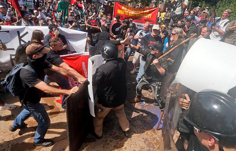 White nationalist demonstrators clash with counter-demonstrators at the entrance to Lee Park in Charlottesville, Virginia, on August 12, 2017. A Unite the Right rally is planned in Washington, D.C., on the one-year anniversary of the Charlottesville demonstrations. (AP Photo/Steve Helber)