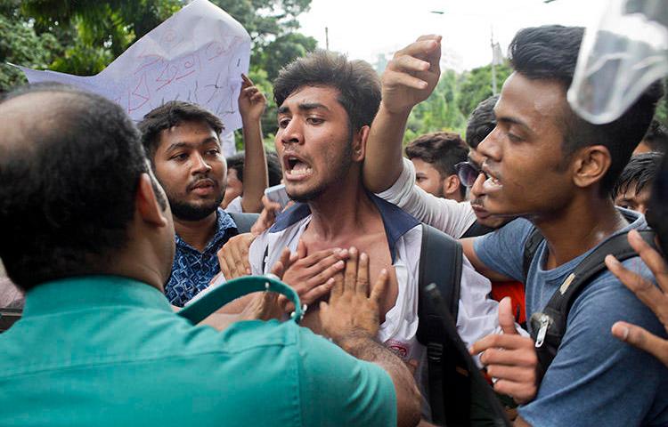 Bangladeshi students attempt to break a police barricade during a protest in Dhaka on August 1. More than a dozen journalists have been attacked covering the nationwide protests. (AP/A. M. Ahad)