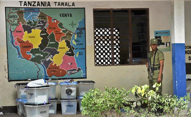 Tanzanian police stand guard outside a vote counting center at a school in Dar es Salaam, Tanzania, on October 28, 2015. On August 16, 2018, CPJ joined a call for the UN Human Rights Council to address a crackdown on free expression and other rights in Tanzania. (AP Photo/Khalfan Said)