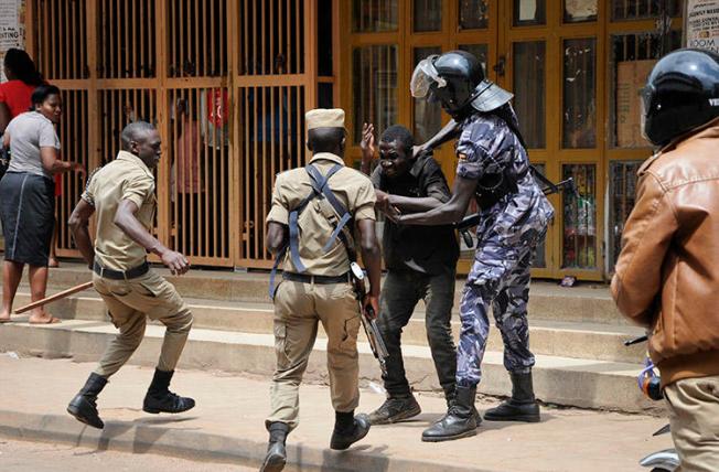 Security forces detain a protester in Kampala on August 20. Security personnel beat and detained at least four journalists who were covering unrest in Uganda's capital. (AP/Ronald Kabuubi)