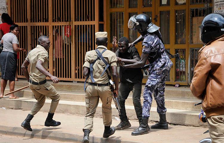 Security forces detain a protester in Kampala on August 20. Security personnel beat and detained at least four journalists who were covering unrest in Uganda's capital. (AP/Ronald Kabuubi)