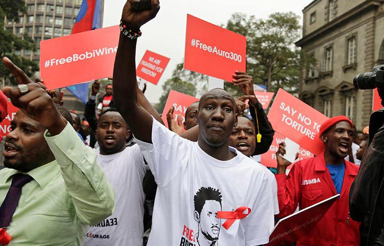 Supporters of a jailed Ugandan lawmaker known as Bobi Wine protest outside the country's embassy in Nairobi, Kenya, on August 23. A Ugandan radio show host was detained overnight after his show broadcast a discussion on the lawmaker's arrest and recent protests. (AP/Khalil Senosi)
