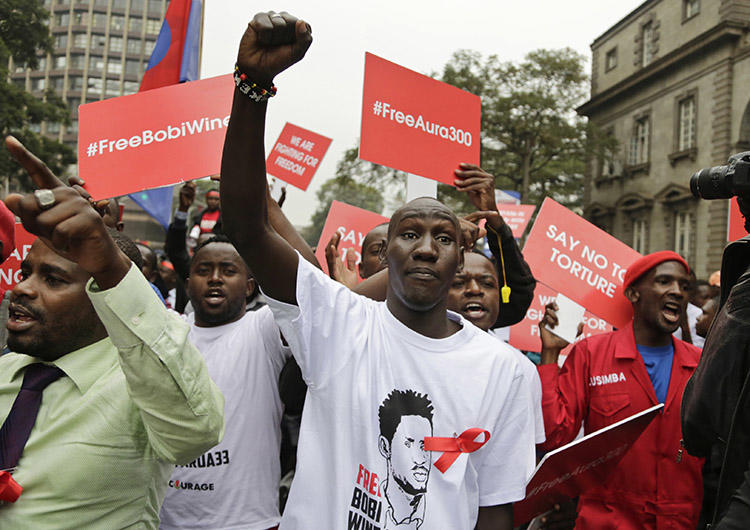 Supporters of a jailed Ugandan lawmaker known as Bobi Wine protest outside the country's embassy in Nairobi, Kenya, on August 23. A Ugandan radio show host was detained overnight after his show broadcast a discussion on the lawmaker's arrest and recent protests. (AP/Khalil Senosi)