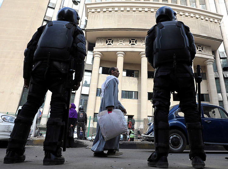 Egyptian security forces stand guard outside a Cairo court during a high-profile trial in January 2018. Prosecutors in August ordered four journalists to be detained on charges of false news and belonging to a banned group. (Reuters/Mohamed Abd El Ghany)