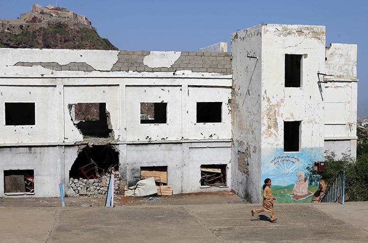 A Yemeni student runs on September 16, 2018, at a school that was damaged last year in an airstrike during fighting between Saudi-backed military coalition forces and Houthis in the city of Taiz. A Saudi airstrike hit a Houthi-controlled radio station in Hodeida Governorate on September 16, killing three employees. (AFP/Ahmad al-Basha)