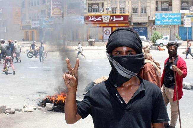 A Yemeni flashes a victory sign during protests in Aden on September 5. Yemeni journalists covering the militias and coalition forces vying for power in the country say they face threats from all sides. (AFP/Saleh al-Obeidi)