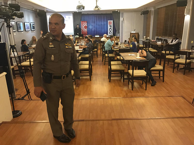 A Thai policeman stands inside the Foreign Correspondents' Club of Thailand on September 10, 2018, during a forum to discuss alleged human rights abuses by the military junta in Myanmar. The discussion was shut down by the Thai authorities. (AP Photo/Tassanee Vejpongsa)