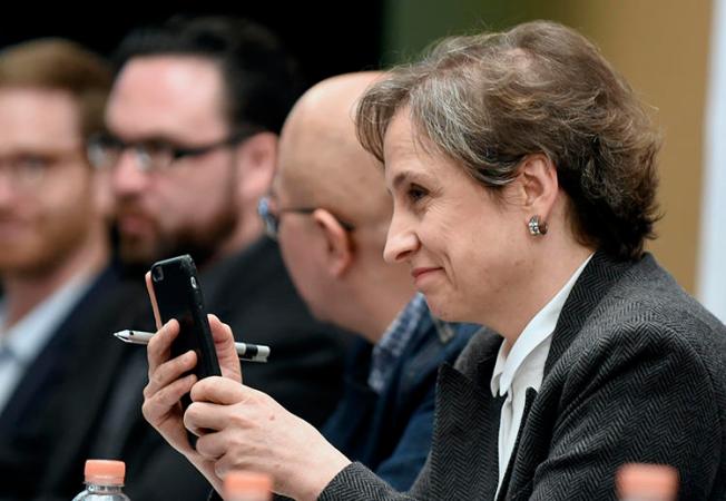 La periodista mexicana Carmen Aristegui sostiene su teléfono móvil durante una conferencia de prensa realizada en Ciudad de México en 2017 para hablar sobre el uso de programas espías contra los periodistas por parte de los Gobiernos. (AFP/Alfredo Estrella)
