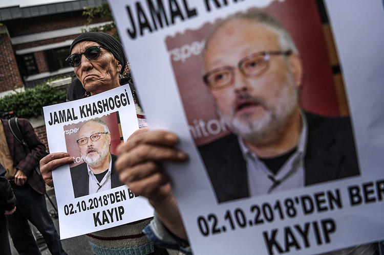 In an October 9 file photo, protesters outside the Saudi consulate in Istanbul hold portraits of critical Saudi journalist Jamal Khashoggi. Saudi Arabia today said the journalist was killed during a fight in the consulate. (AFP/Ozan Kose)