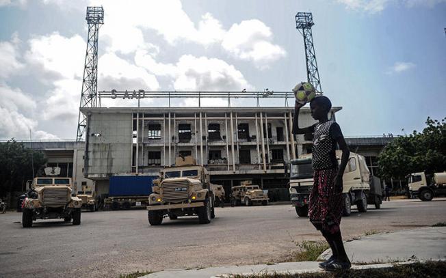 A Somali boy, pictured in August 2018, watches as soldiers for the African Union Mission leave the Mogadishu stadium they used for years as a base. Gunmen in October shot dead a radio journalist in a town about 17km from the capital. (AFP/Mohamed Abdiwahab)