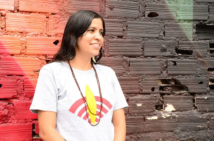 Renata Machado, fundadora da Rádio Yandê, na foto com o logotipo da estação. A Rádio Yandê é um dos poucos veículos que conta as histórias dos povos indígenas do Brasil em seus próprios termos. (Alfredo Boc Boc)