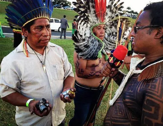 A member of Rádio Yandê speaks with demonstrators as they hold tear gas capsules, during a rally in 2017. (Daiara Tukano)