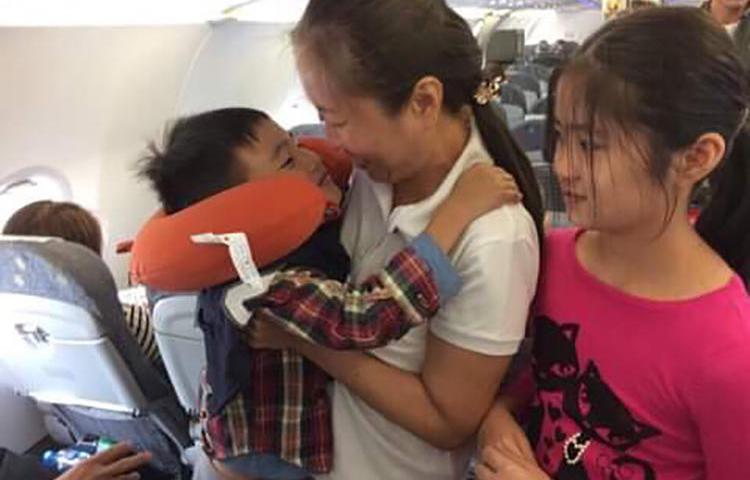 Vietnamese blogger Nguyen Ngoc Nhu Quynh, known by her pen name "Mother Mushroom," with her two children on a plane on the way to the U.S. after being freed from prison in Vietnam on October 17, 2018. (Family photo)