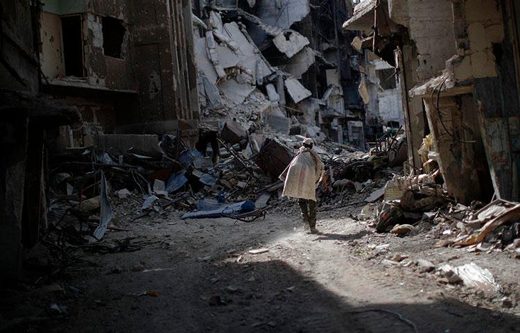 A man walks through rubble in Damascus in October 2018, caused by years of war. Safety remains a key concern for Syrian journalists. (AP/Hassan Ammar)