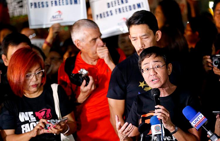 Maria Ressa, right, CEO of Rappler, an online news agency, addresses a rally of journalists and supporters during a protest against the Securities and Exchange Commission's order to revoke its registration on January 19, 2018, northeast of Manila, Philippines. Philippine authorities in November 2018 threatened to charge Ressa and Rappler with tax evasion. (AP Photo/Bullit Marquez)