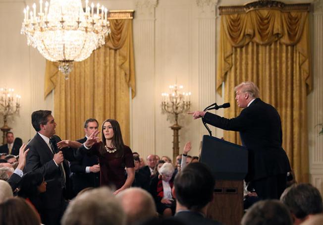 A White House staff member reaches for the microphone held by CNN's Jim Acosta as he questions President Donald Trump during a news conference at the White House in Washington, D.C., on November 7, 2018. The White House revoked Acosta's credentials later that day. (Reuters/Jonathan Ernst)