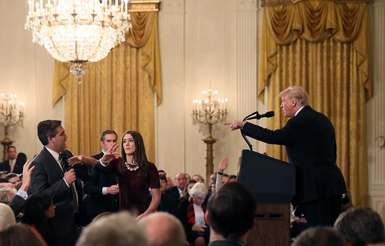 A White House staff member reaches for the microphone held by CNN's Jim Acosta as he questions President Donald Trump during a news conference at the White House in Washington, D.C., on November 7, 2018. The White House revoked Acosta's credentials later that day. (Reuters/Jonathan Ernst)