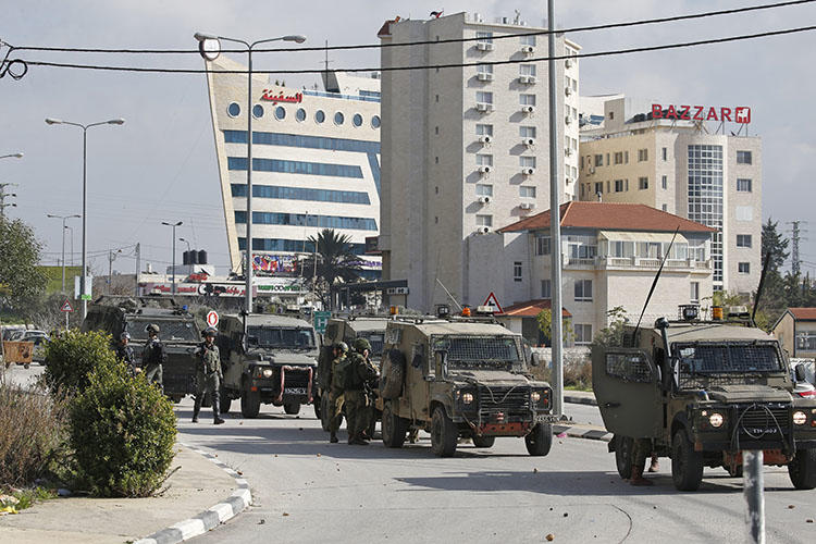 Israeli soldiers deploy during clashes in the West Bank city of Ramallah following a raid on December 10, 2018, one day after a drive-by shooting attack next to a settlement in which many Israelis were injured. Israeli forces raided the offices of the official Palestinian news agency, and detained a Palestinian journalist. (AFP/Abbas Momani)
