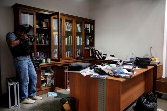 A local photographer makes a video of journalist Carlos Fernando Chamorro's office the day after it was raided by the national police in Managua, Nicaragua. (REUTERS/Oswaldo Rivas)