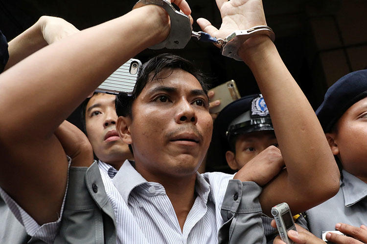 Reuters journalist Kyaw Soe Oo is led handcuffed from a court in Yangon in September. He and colleague Wa Lone are serving seven-year prison sentences in Myanmar. (Reuters/Ann Wang)