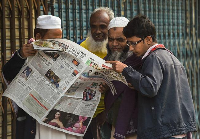 People read a newspaper carrying headlines of the general election results in Dhaka on December 31, 2018. Several journalists were attacked and one was detained while covering the vote. (AFP/Indranil Mukherjee)