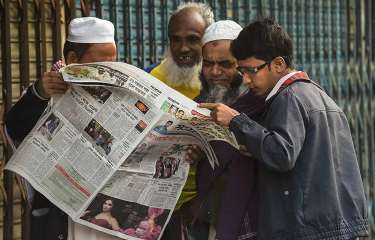 People read a newspaper carrying headlines of the general election results in Dhaka on December 31, 2018. Several journalists were attacked and one was detained while covering the vote. (AFP/Indranil Mukherjee)