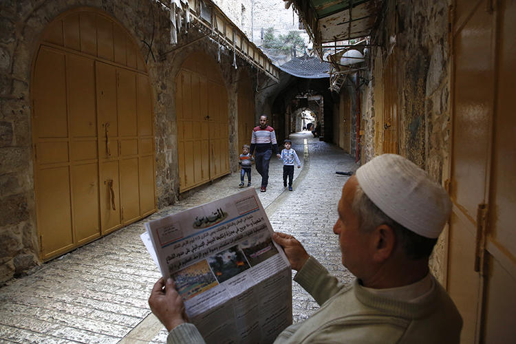 A Palestinian man reads a newspaper on March 31, 2018. A reporter for the London-based Quds Press News Agency, Yousef al-Faqeeh, was recently detained in the West Bank. (Hazem Bader/AFP)