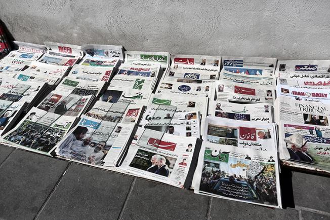 Iranian newspapers lay on the ground in front of a kiosk in Tehran on April 4, 2015. On January 23, 2019, journalist Yashar Soltani, who reported on corruption in Tehran land deals, was sentenced to five years in prison. (Behrouz Mehri/AFP)