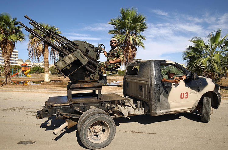 Members of Libyan security forces loyal to Libyan National Army head Khalifa Haftar operate turrets mounted on pickup trucks in eastern Libya in October 2018. A photojournalist was detained on December 20, 2018, in the eastern city of Ajdabiya. (AFP/Abdullah Doma)