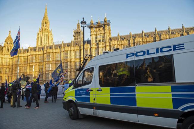 Police officers watch as anti-Brexit activists demonstrate opposite the Houses of Parliament in London on January 8, 2019. Police were called in after journalists and a member of parliament were harassed by pro-Brexit demonstrators on January 7.