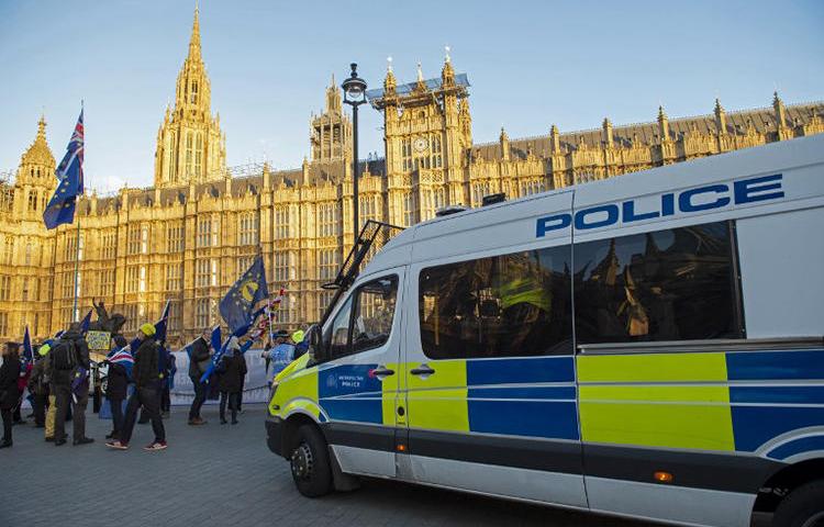 Police officers watch as anti-Brexit activists demonstrate opposite the Houses of Parliament in London on January 8, 2019. Police were called in after journalists and a member of parliament were harassed by pro-Brexit demonstrators on January 7.