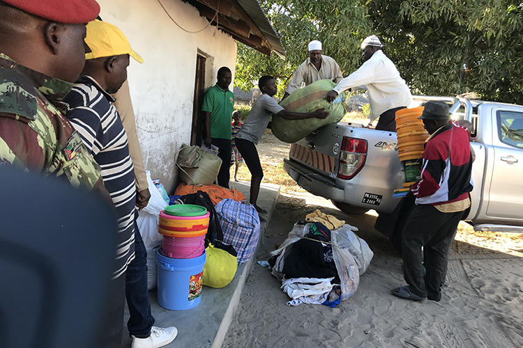 Internally displaced people offload food, blankets, and other goods after fleeing militant attacks in Naunde, northern Mozambique, on June 13, 2018. A Mozambican journalist was arrested on January 5, 2019, and held in a military prison after photographing families who fled the militant attacks. (AFP/Joaquim Nhamirre)