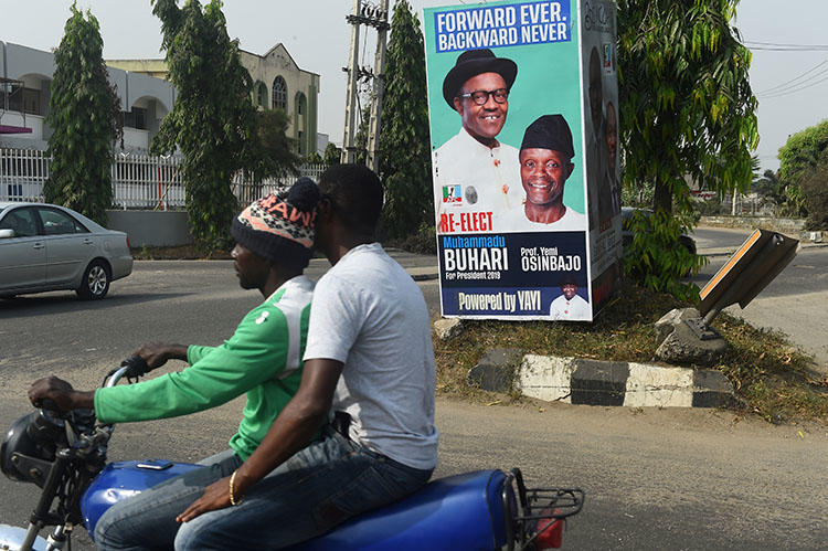 A campaign poster for Nigeria's incumbent president and candidate Muhammadu Buhari and his Vice-President Yemi Osinbajo, pictured in Lagos, on January 4. At least three journalists were injured by stray bullets after a fight broke out at a campaign rally for the ruling APC party. (AFP/Pius Utomi Ekpei)