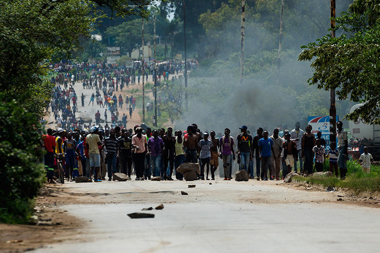 Protesters block the main route to Zimbabwe's capital Harare from Epworth township on January 14, 2019, after the government more than doubled the price of fuel. On January 15, CPJ joined more than 20 rights organizations and the #KeepItOn Coalition to call for authorities in Zimbabwe to restore internet and social media services. (AFP/Jekesai Njikizana)