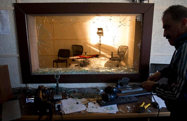 An employee checks the damage in a studio after a raid by assailants on the offices of the Palestinian Broadcasting Corporation in Gaza City on Friday, January 4, 2019. (AP Photo/Khalil Hamra)