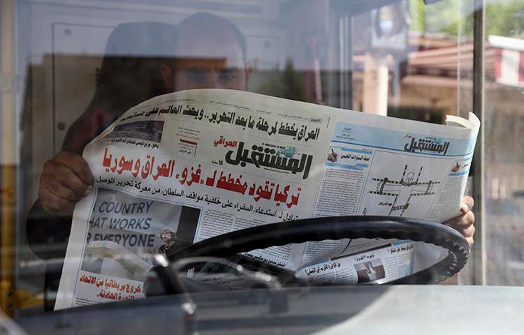 An Iraqi man reads a newspaper on October 6, 2016. In recent weeks, at least four journalists were detained in northern Iraq and Iraqi Kurdistan.