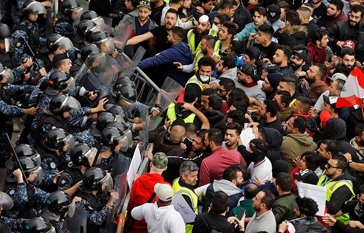 Anti-government protesters clash with riot police in central Beirut, Lebanon, on December 23, 2018. Multiple reporters were harassed and assaulted while covering the protests. (AP/Bilal Hussein)