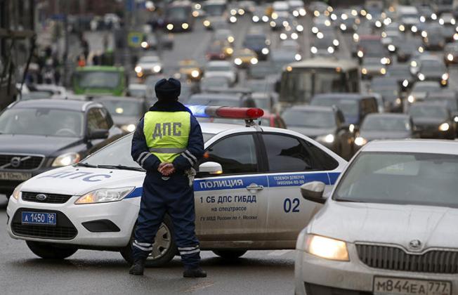 A Russian traffic police officer stands guard as vehicles drive past in central Moscow. In Far Eastern Russia, a blogger was recently detained by authorities, ostensibly for a traffic violation. He maintains that the arrest is linked to a video he shared online. (Sergei Karpukhin/Reuters)